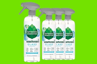 four clear bottles of glass cleaner on a green background