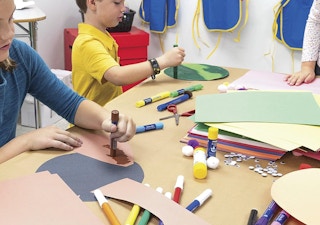 kids at a table making crafts with construction paper
