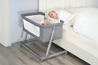 Lifestyle image of mom sleeping in bed with baby next to her in the bedside sleeper 