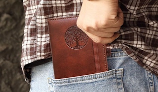 a person putting a notebook in their back pocket