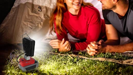 a LED work in front of two people next to a tent