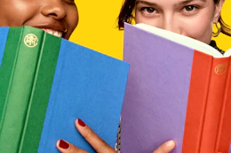 Lifestyle image of 2 people with books up to their face