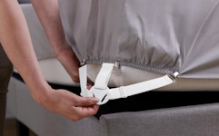 a bed sheet holder being put on a bed
