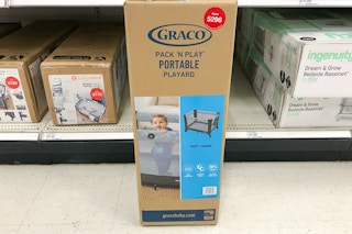 graco pack n play sitting on the floor in front of a target shelf