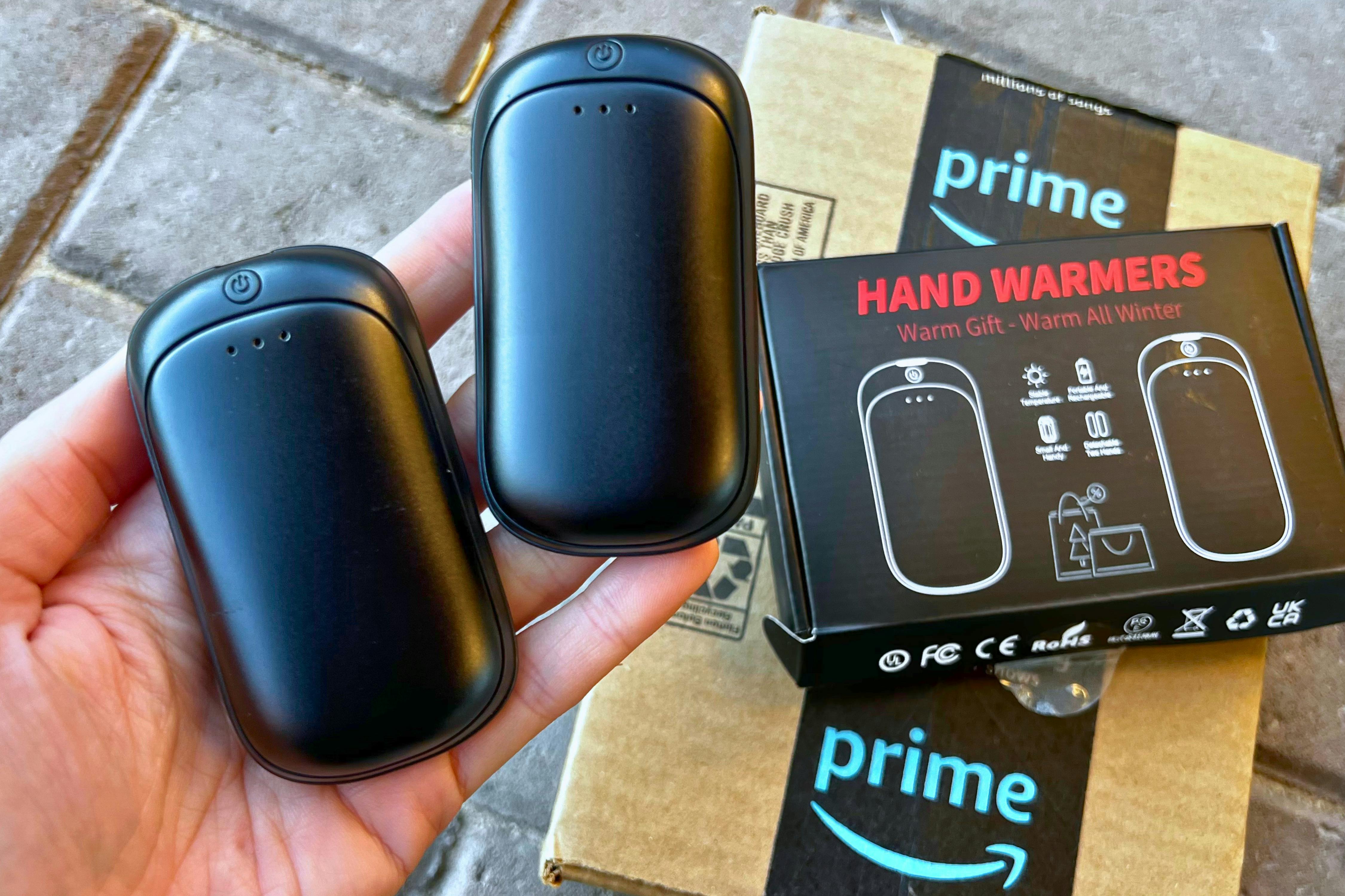 Person holding the Lerat Hand Warmers Rechargeable next to an Amazon package.