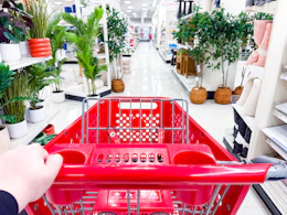 Target shopping cart being pushed down center aisle of home section in Target store