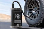  Aneson Tire Inflator Portable Air Compressor sitting on the ground next to a vehicle tire.