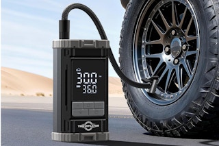  Aneson Tire Inflator Portable Air Compressor sitting on the ground next to a vehicle tire.