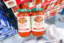 hand holding a two-pack of rao's pasta sauce at costco
