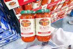 hand holding a two-pack of rao's pasta sauce at costco