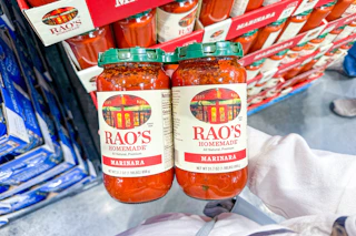 hand holding a two-pack of rao's pasta sauce at costco