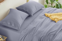 a silver grey sheet set on a bed
