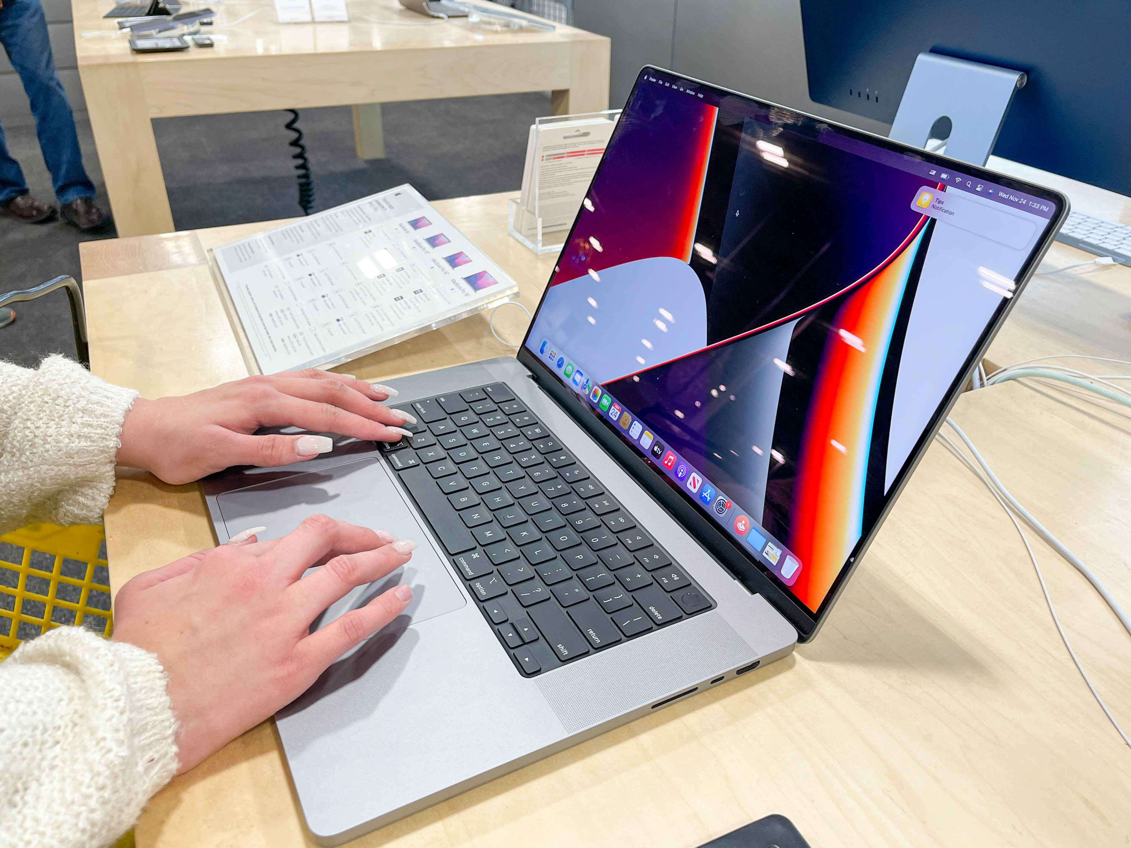 A womens hands on the key board of an apple computer at Best Buy