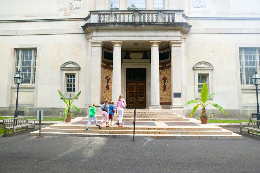 Family of four walking into the entrance of a museum