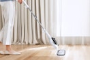 Woman using the Sprobil 11-in-1 Steam Mop on her floors.