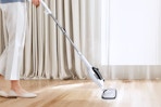 Woman using the Sprobil 11-in-1 Steam Mop on her floors.