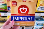 hand holding a pack of imperial butter