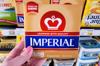 hand holding a pack of imperial butter