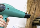 person blow drying hair