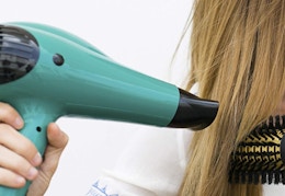 person blow drying hair