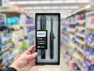 hand holding Philips One Sonicare Toothbrush and case