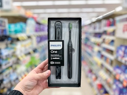 hand holding Philips One Sonicare Toothbrush and case