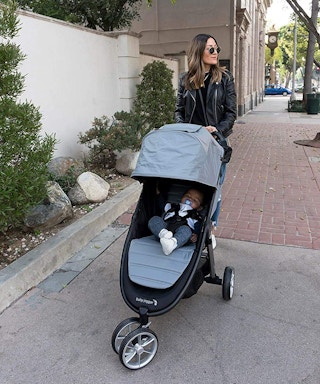 A woman pushing her baby in a Baby Jogger stroller.