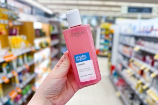 person holding loreal hydrafresh toner in an aisle