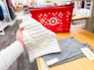 hand holding a womens tee in front of target hand cart