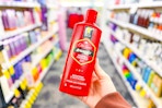 person holding a bottle of old spice shampoo in an aisle