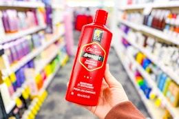 person holding a bottle of old spice shampoo in an aisle