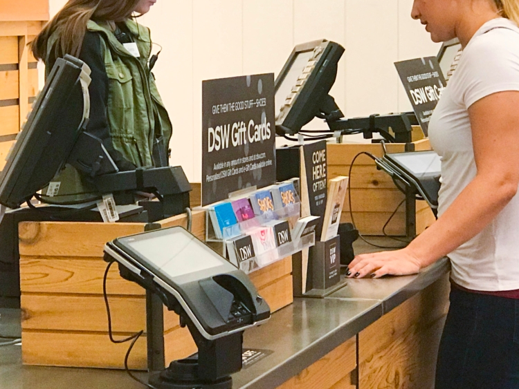 Person standing at DSW checkout returns counter