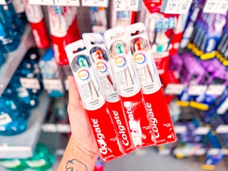 Colgate toothbrushes in a hand