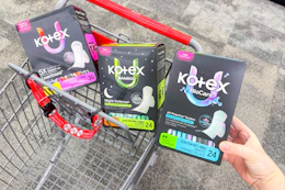 hand holding a box of kotex pads