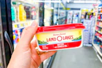 hand holding a tub of land o lakes spreadable butter