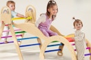Kids playing on the Pikler Triangle Set, 9-in-1 Foldable Wooden Climbing Toy.