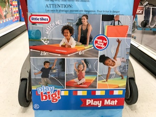 close up of little tikes play mat in front of a target cart
