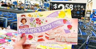 Someone holding boxes of Little Debbie Mother's Day Cakes in Walmart