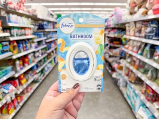 hand holding febreze bathroom air freshener in walgreens
