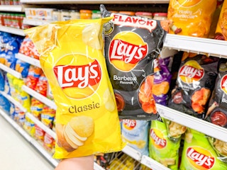 hand holding 2 frito-lay chip bags at target