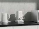 a tower surge protector on a counter with kitchen appliances