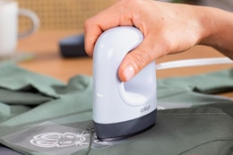 a person using a cricut mini heat press on a shirt