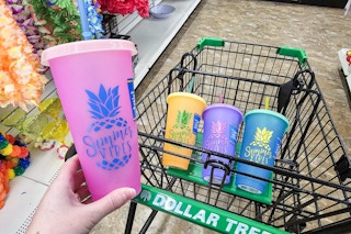 person holding a pink color changing cup over a cart w/ 3 more cups