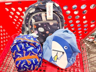 a shark, dinosaur, and solar system Cat & Jack backpack in a Target cart