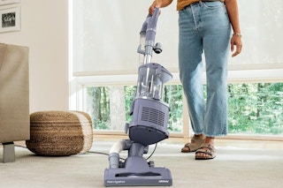 Woman using the Shark NV352 Navigator Lift Away Upright Vacuum.