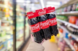 hand holding a coca-cola 6-pack