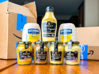 variety of mayo and mustard products on a table with Amazon boxes