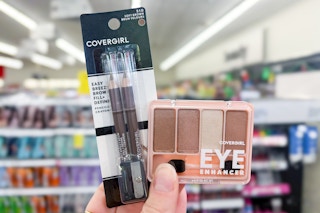 person holding covergirl eyeliner and eyeshadow