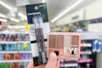 person holding covergirl eyeliner and eyeshadow