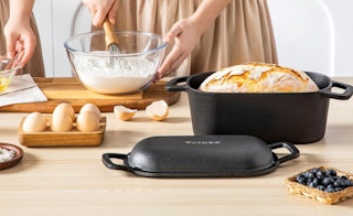 a bread in a dutch oven on a counter with baking ingredients 